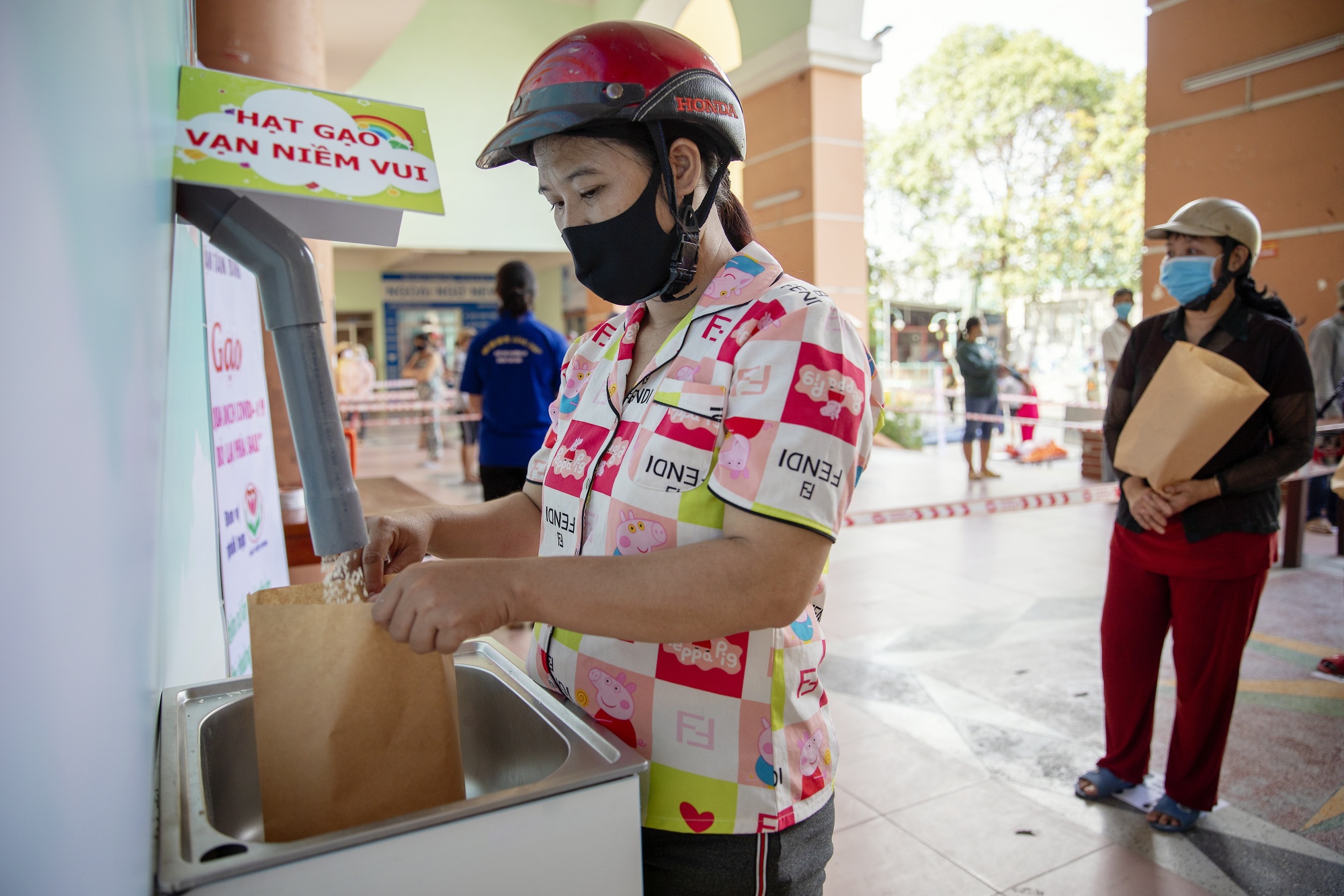 A woman receives rice from a ‘rice ATM’ in the Tan Binh district of Ho Chi Minh City, April 22.