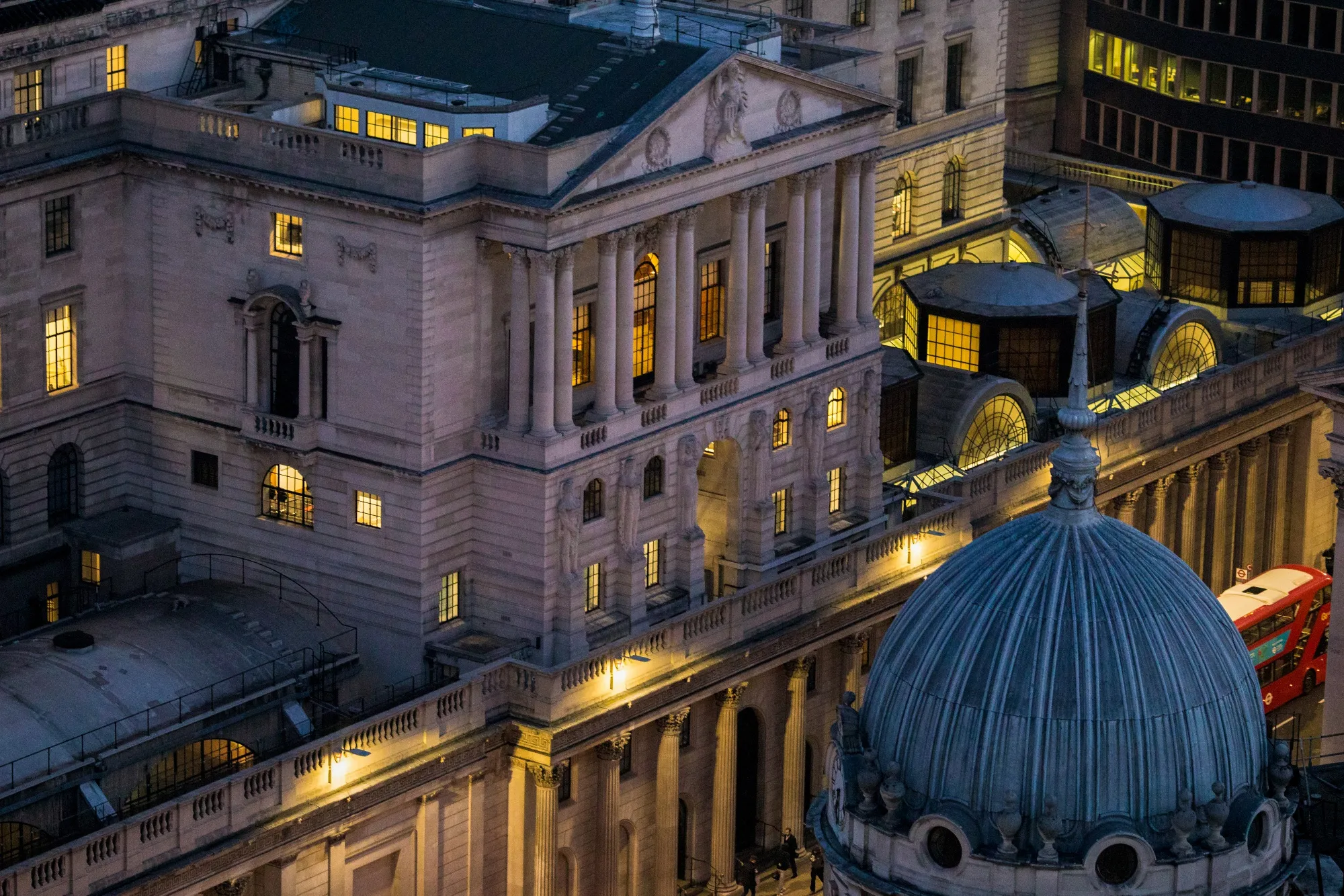 The Bank of England stands illuminated at dawn in the City of London.