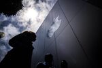 Pedestrians walk past an Apple Inc. store.