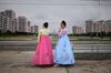 Tourists from Russia wearing traditional Korean dress smoke cigarettes as they stand beside a road in Pyongyang on June 19, 2019. (Photo by Ed JONES / AFP) (Photo credit should read ED JONES/AFP/Getty Images)