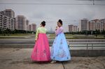 Tourists from Russia wearing traditional Korean dress smoke cigarettes as they stand beside a road in Pyongyang on June 19, 2019. (Photo by Ed JONES / AFP) (Photo credit should read ED JONES/AFP/Getty Images)