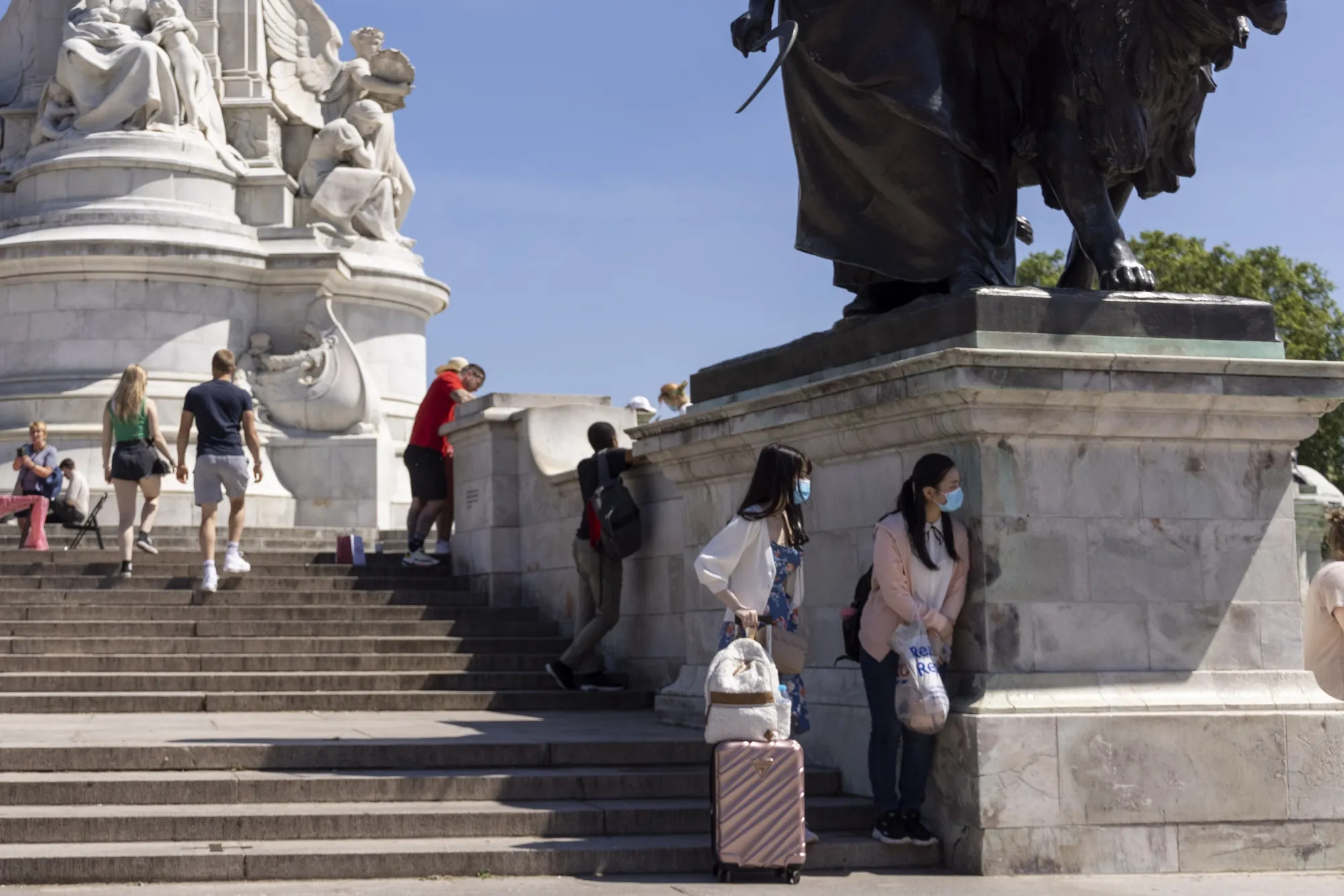 Tourists stand outside Buckingham Palace in London, on June 14.