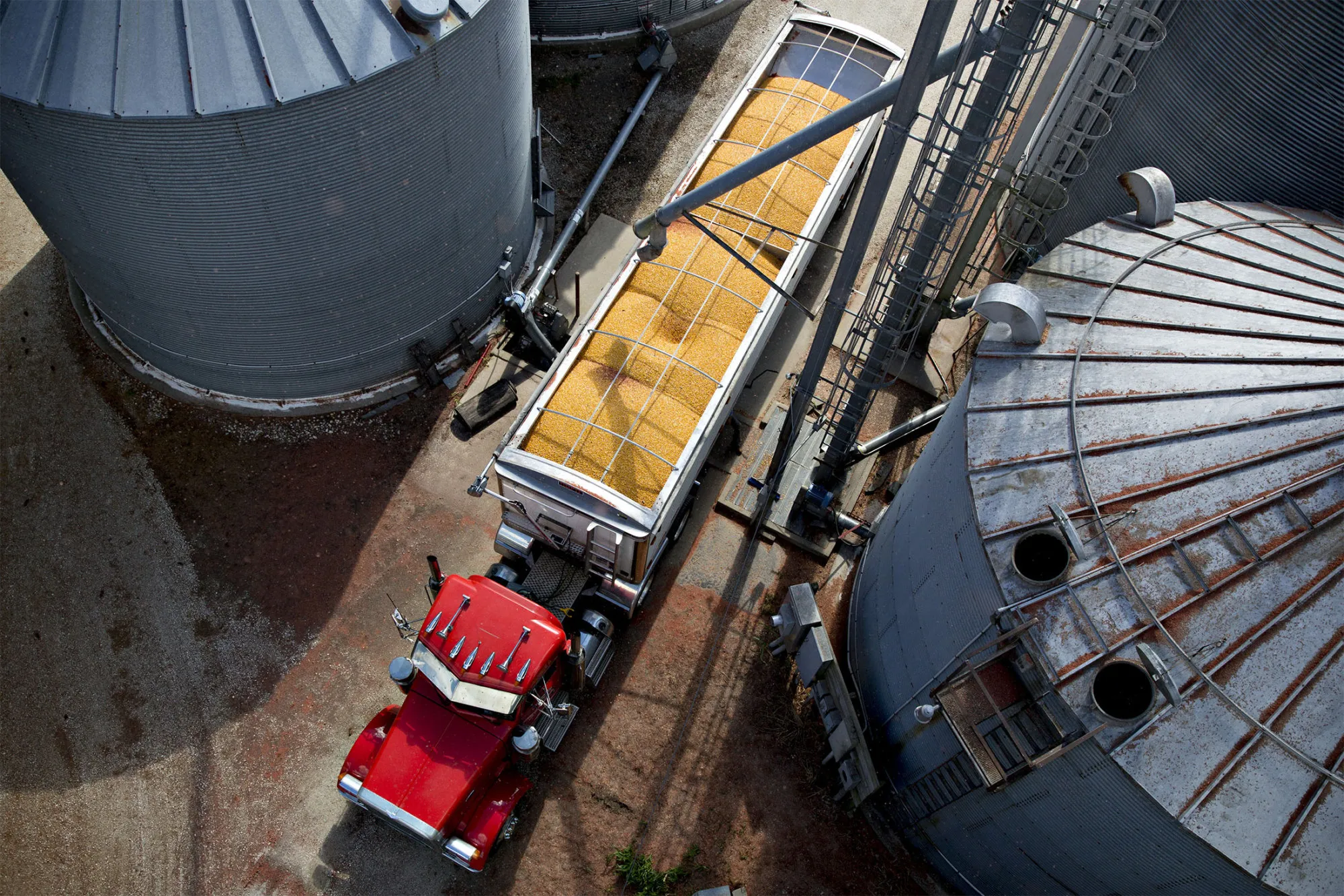 A truck hauls a load of corn between grain bins on a farm during harvest in Walnut, Illinois, U.S., on Monday, Oct. 9, 2017.
