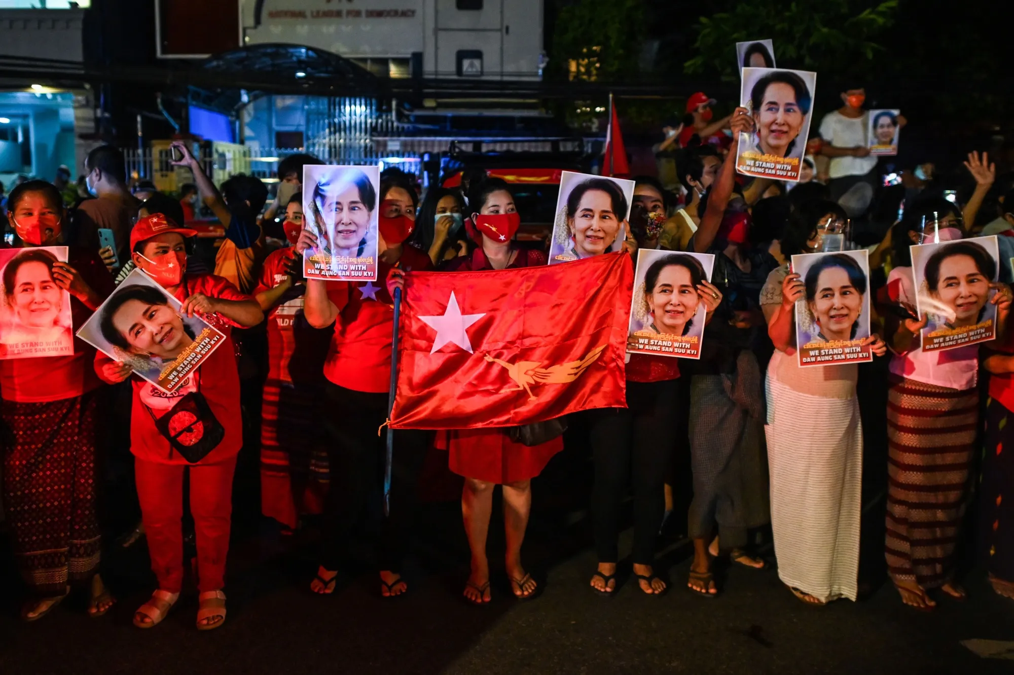 Supporters of the National League for Democracy party hold portraits of Aung San Suu Kyi as they celebrate in front of the party’s headquarters in Yangon, on Nov. 9, 2020.