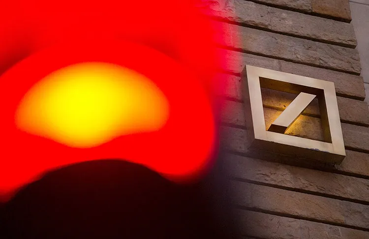 A red road traffic light stands illuminated as the logo of Deutsche Bank AG sits on the exterior of the bank's offices in Berlin, Germany, on Monday, Oct. 12, 2015. Deutsche Bank co-Chief Executive Officer John Cryan may eliminate a dividend that's stood since Germany's postwar reconstruction as he tries to overhaul the firm without asking shareholders for more capital.
