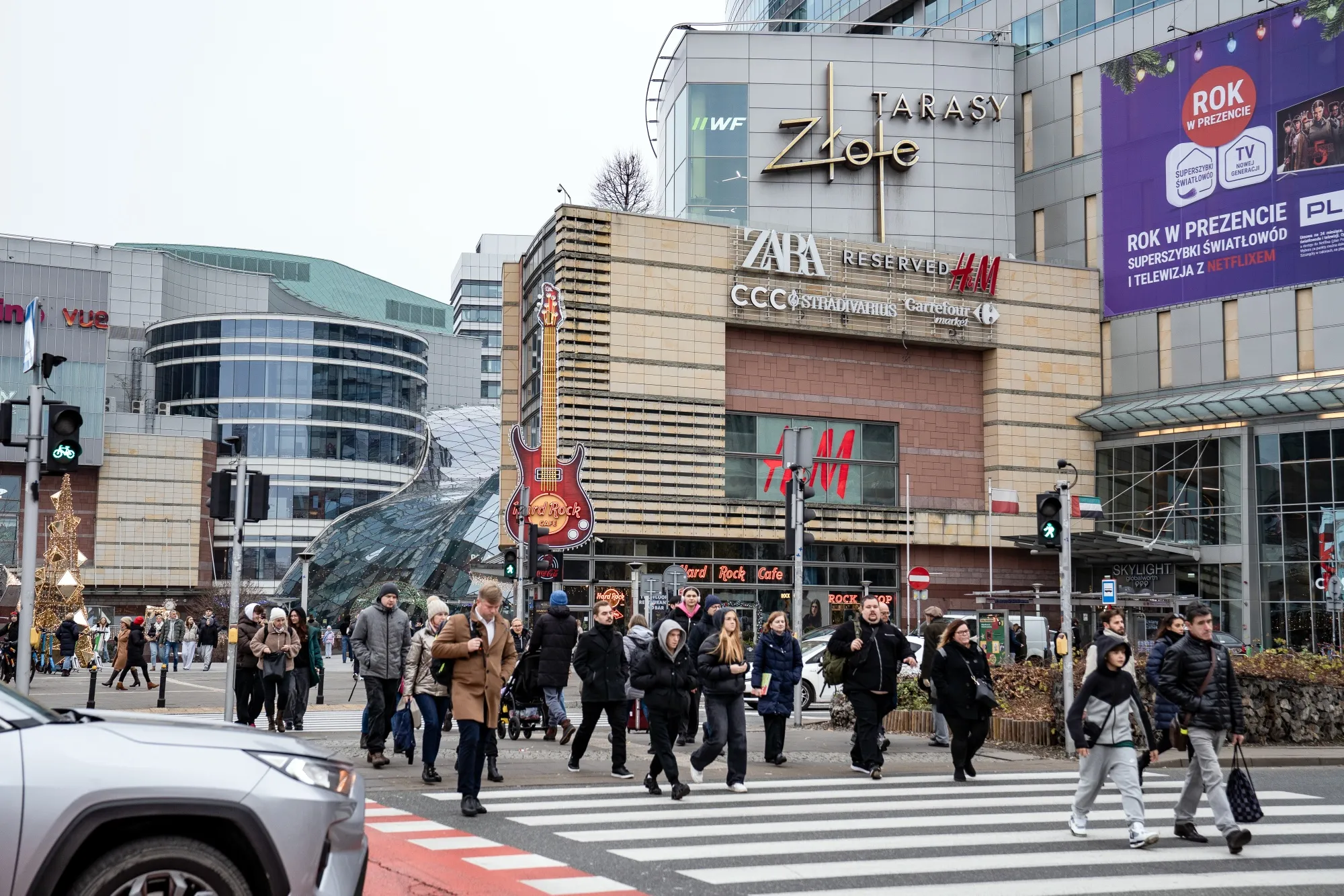 Pedestrians cross a street near a shopping mall in Warsaw.&nbsp;