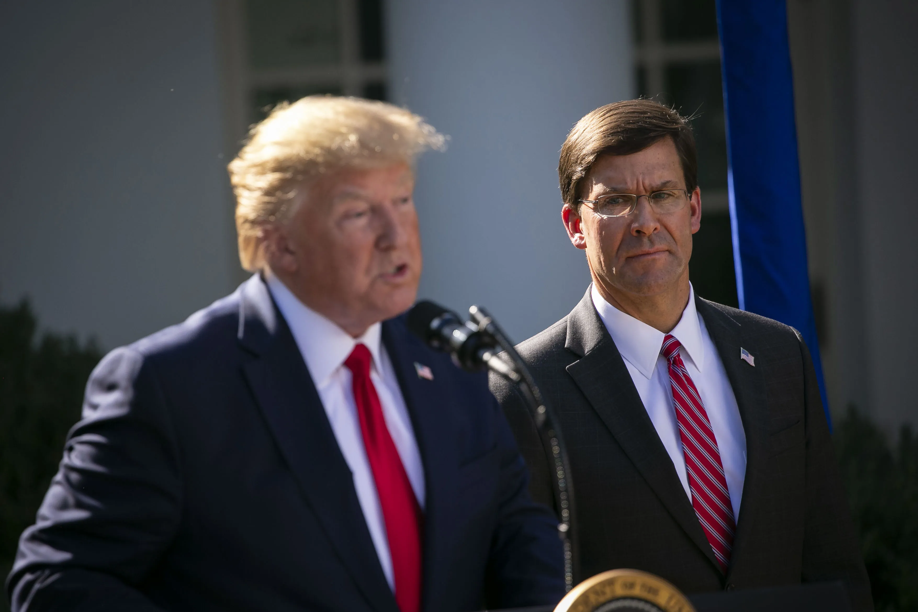 Mark Esper listens as Donald Trump speaks outside the White House in 2019.