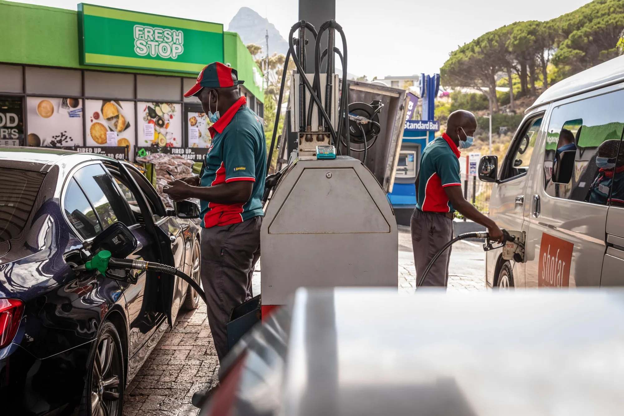 Workers refuel vehicles at a gas station in Cape Town, South Africa.