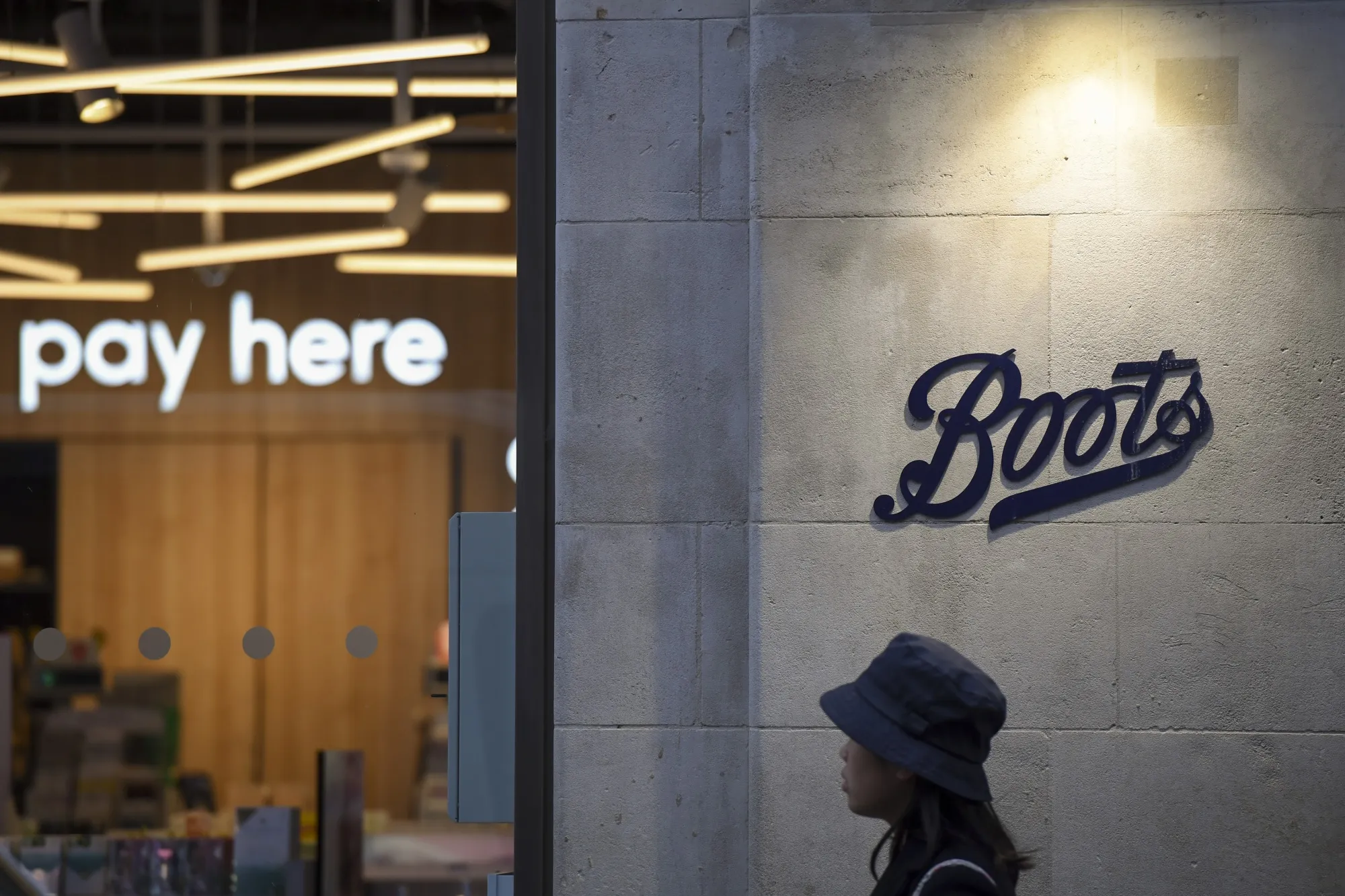 A pedestrian passes a Boots store in London.