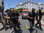Security personnel gather at the site of an attack in Tunis on June 27.