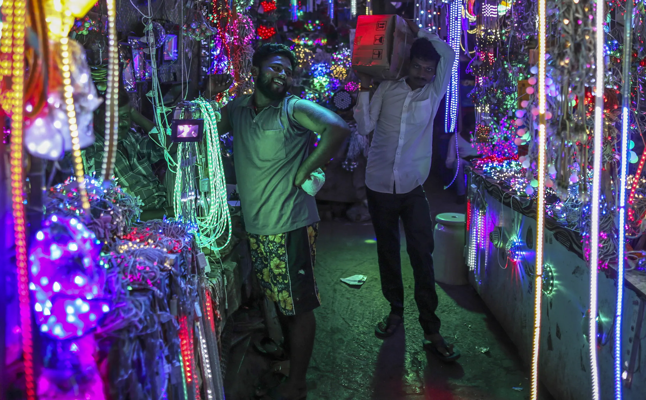 A man carries a box through a wholesale stall near Crawford Market in Mumbai.
