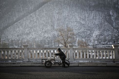A man pushes a bicycle rickshaw.