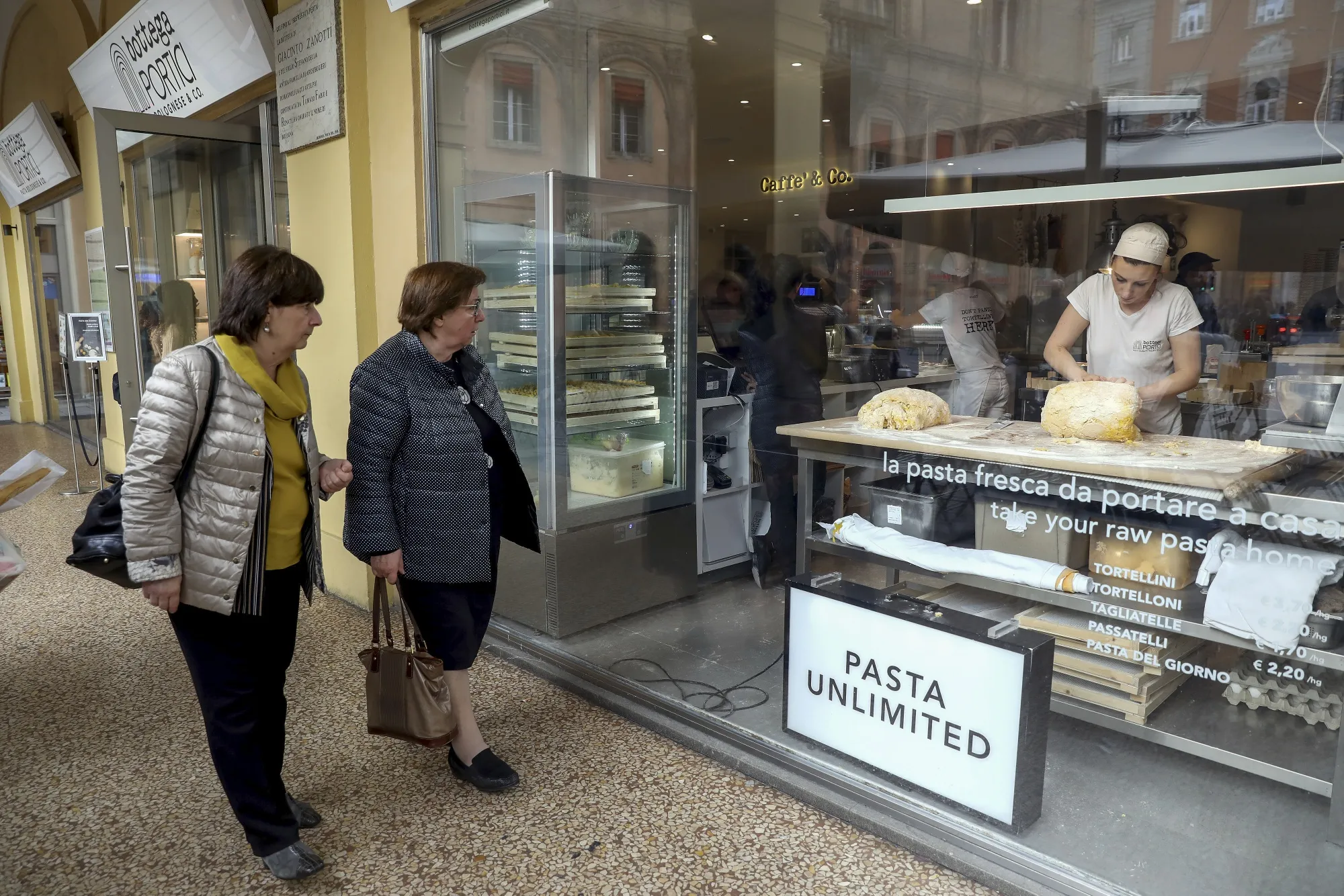 An employee makes fresh pasta inside a takeaway pasta restaurant in Bologna, Italy.