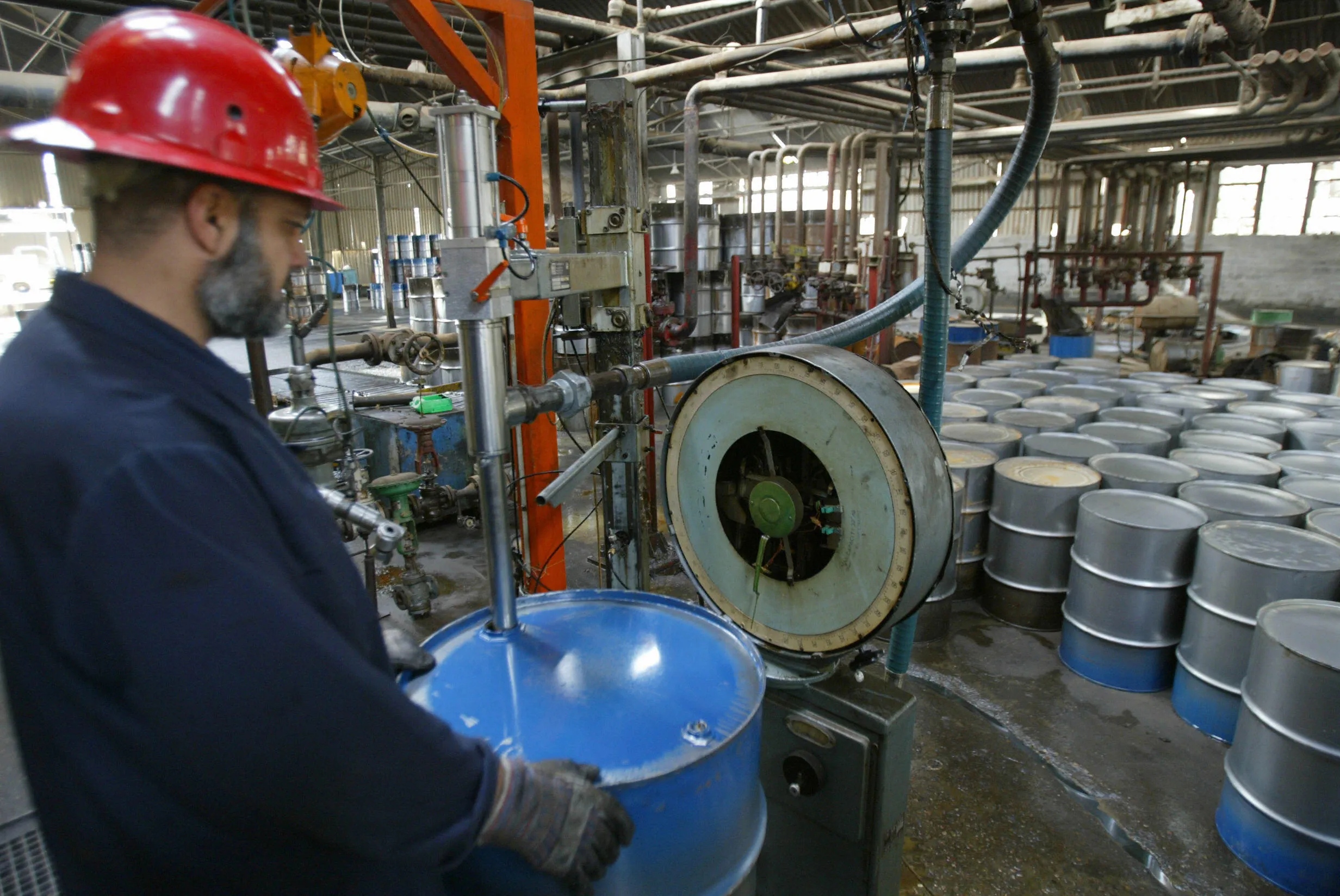 BAGHDAD, IRAQ:  A worker at the Dura oil refinery, on the southern outskirts of Baghdad, fills a barrel 26 January 2004. Iraq's former dictator Saddam Hussein rewarded 200 of his leading supporters abroad by giving them millions of barrels of crude oil, government officials said 25 January.  Oil ministry undersecretary Abdul Sahib Salman Qotob told AFP the supporters included at least two prime ministers and two foreign ministers, as well as high profile politicians and political parties. Journalists and the sons of ministers and heads of states across four continents were also among recipients.       AFP PHOTO/Karim SAHIB  (Photo credit should read KARIM SAHIB/AFP/Getty Images)