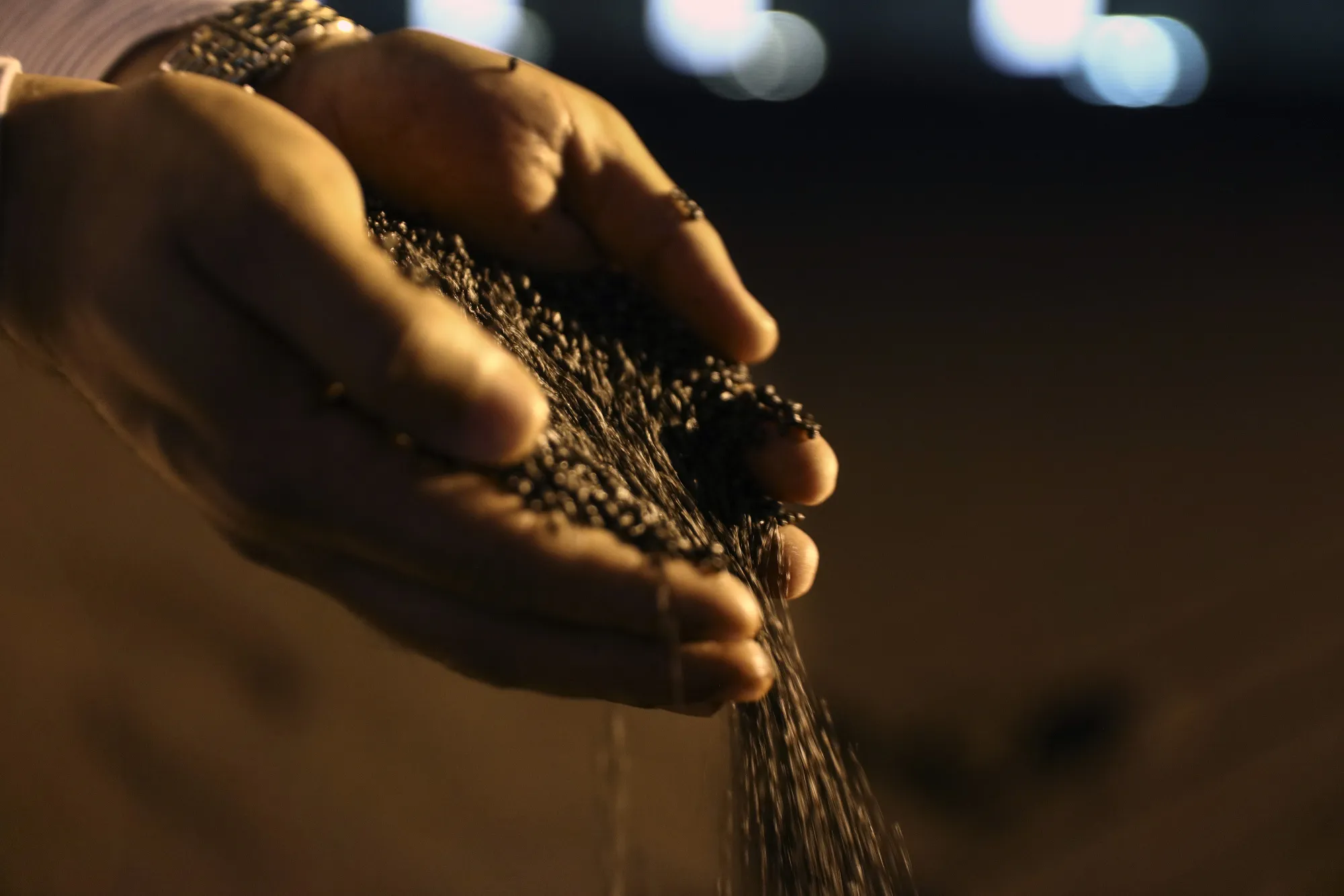 An employee holds a handful of processed diammonium phosphate.