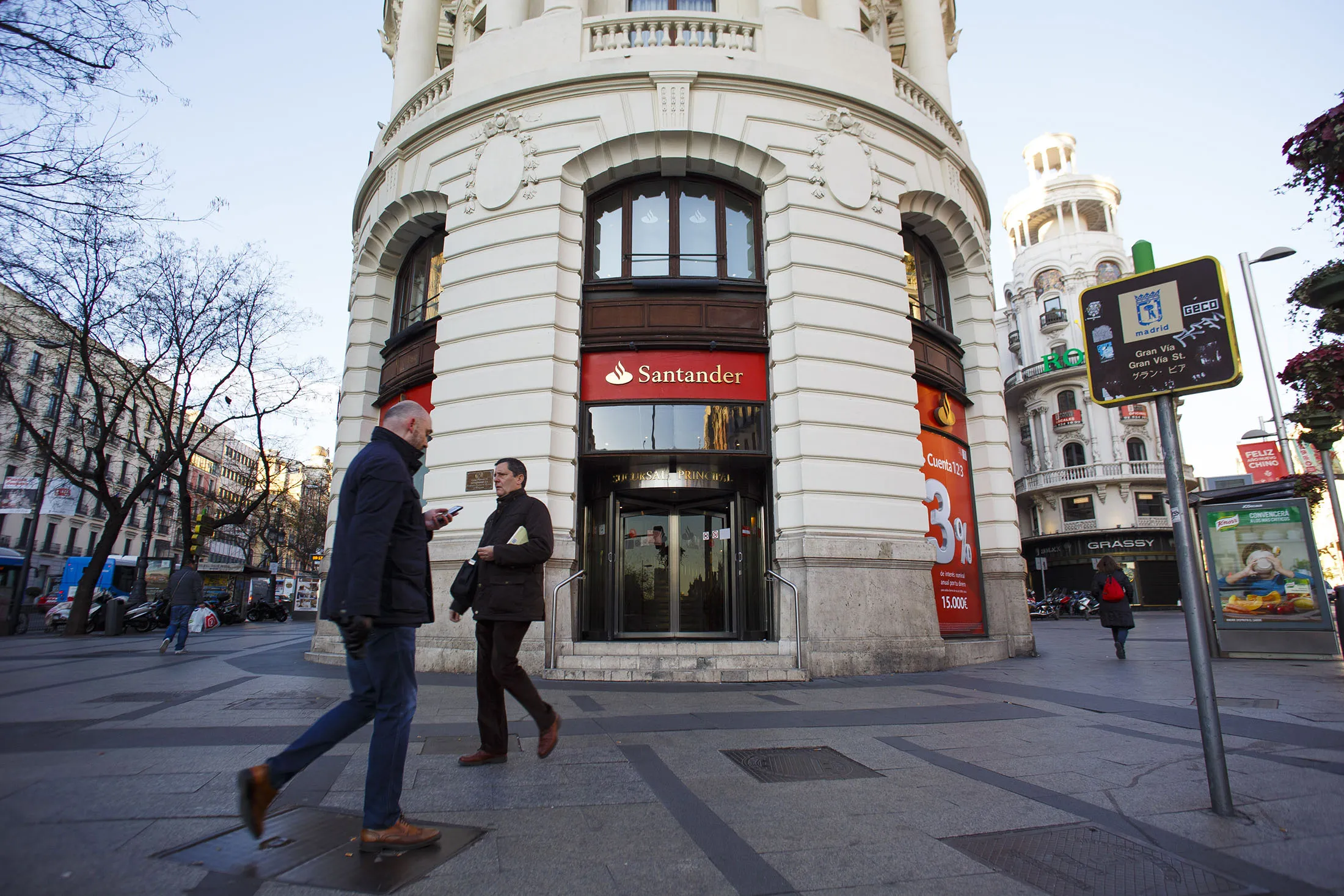 Pedestrians pass a Banco Santander SA bank branch in Madrid, Spain, on Wednesday, Jan 25, 2017. Santander said fourth-quarter profit rose to 1.6 billion euros ($1.72 billion) on lower provisions for bad loans and higher income from fees and from its business in Brazil.
