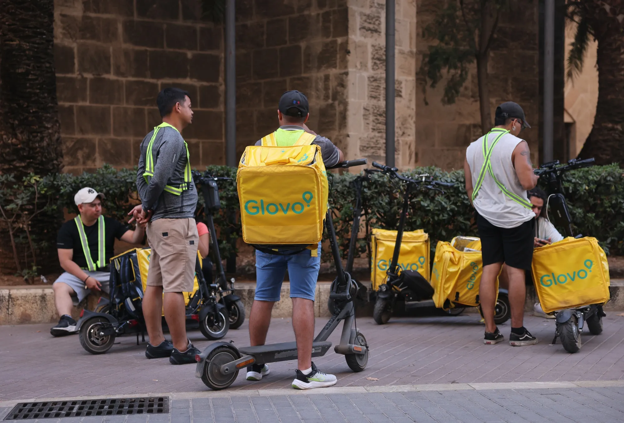 Food couriers working for Glovo on a street in Palma de Mallorca.