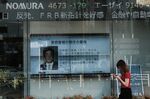 A screen displays a news broadcast on Prime Minister Shinzo Abe outside a securities firm in Tokyo, Japan.