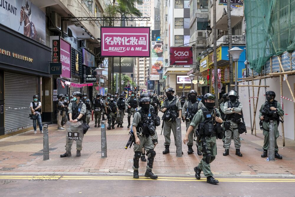 Riot police stand in front of closed stores in the Causeway Bay district during a protest in Hong Kong, China, on Wednesday, May 27, 2020. 