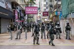 Riot police stand in front of closed stores in the Causeway Bay district during a protest in Hong Kong, China, on Wednesday, May 27, 2020.