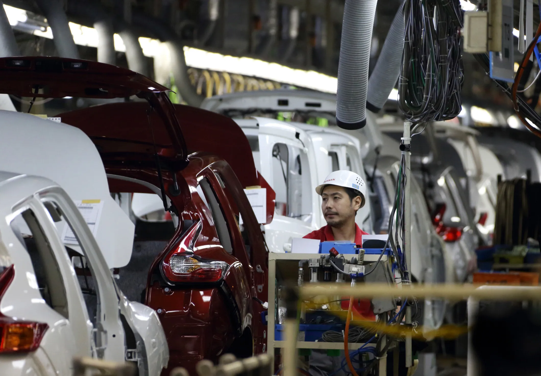 A worker assembles a vehicle on the production line of the Nissan Oppama plant in Yokosuka, Japan.
