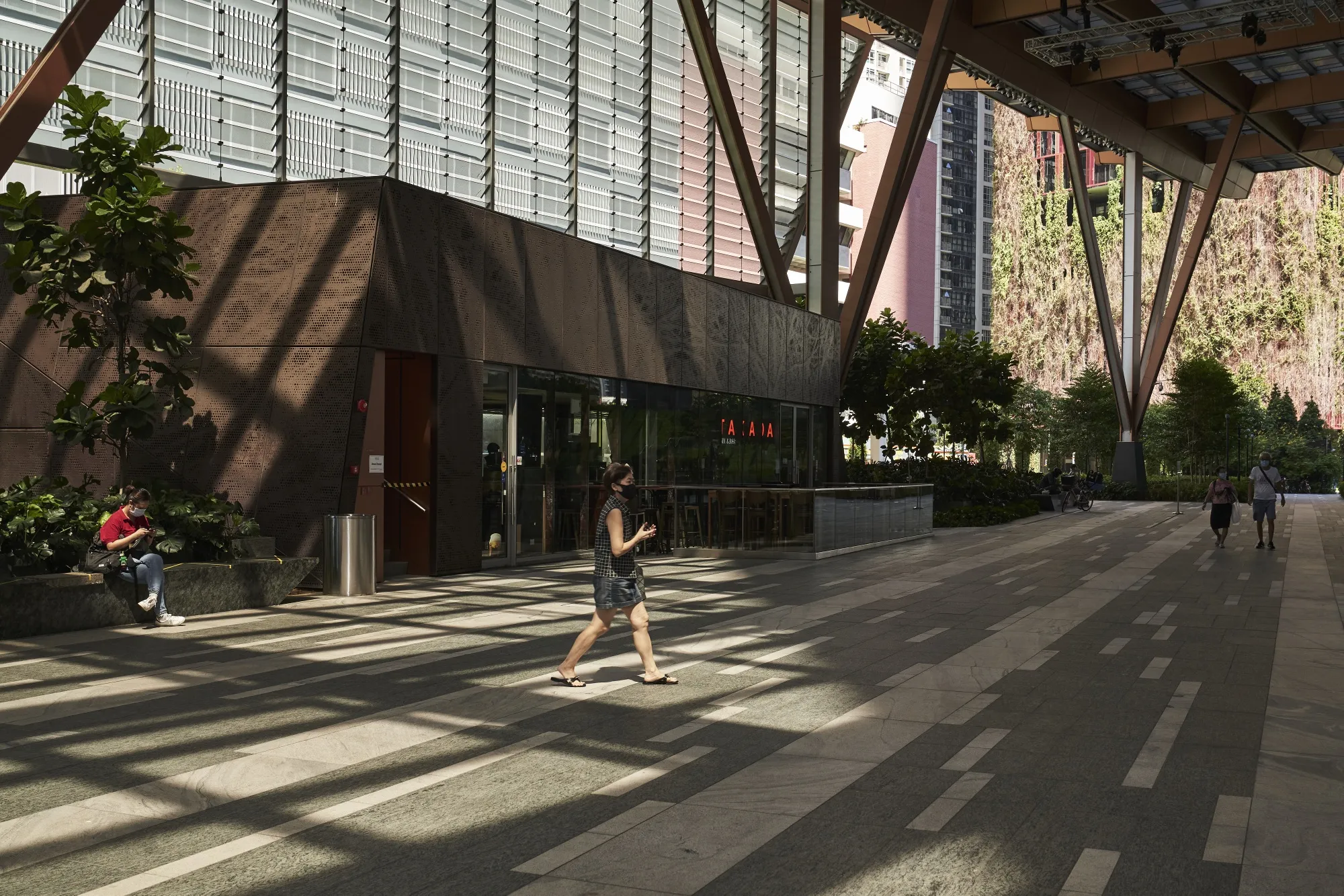 A pedestrian wearing a protective mask walks through the garden area at Guoco Tower in the central business district of Singapore, on&nbsp;June 2.