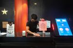 An employee wearing a protective mask and gloves cleans a concession stand at the AMC Lincoln Square 13 movie theater in New York, U.S., on Thursday, June 10, 2021.