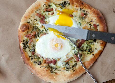Barbuto's pizza uovo, featuring oven baked eggs, salsa verde, and pancetta.