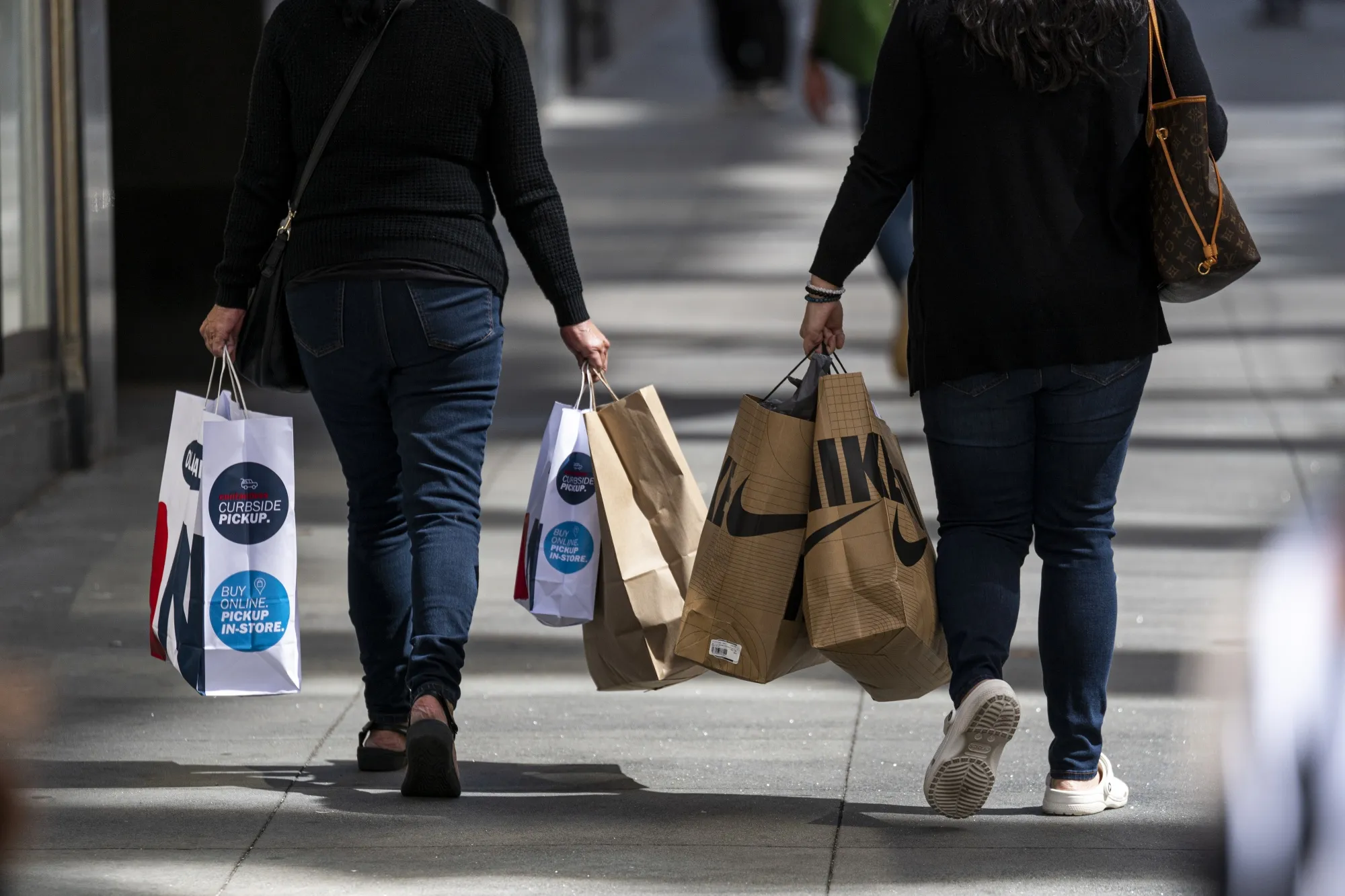 Pedestrians carry shopping bags in San Francisco.