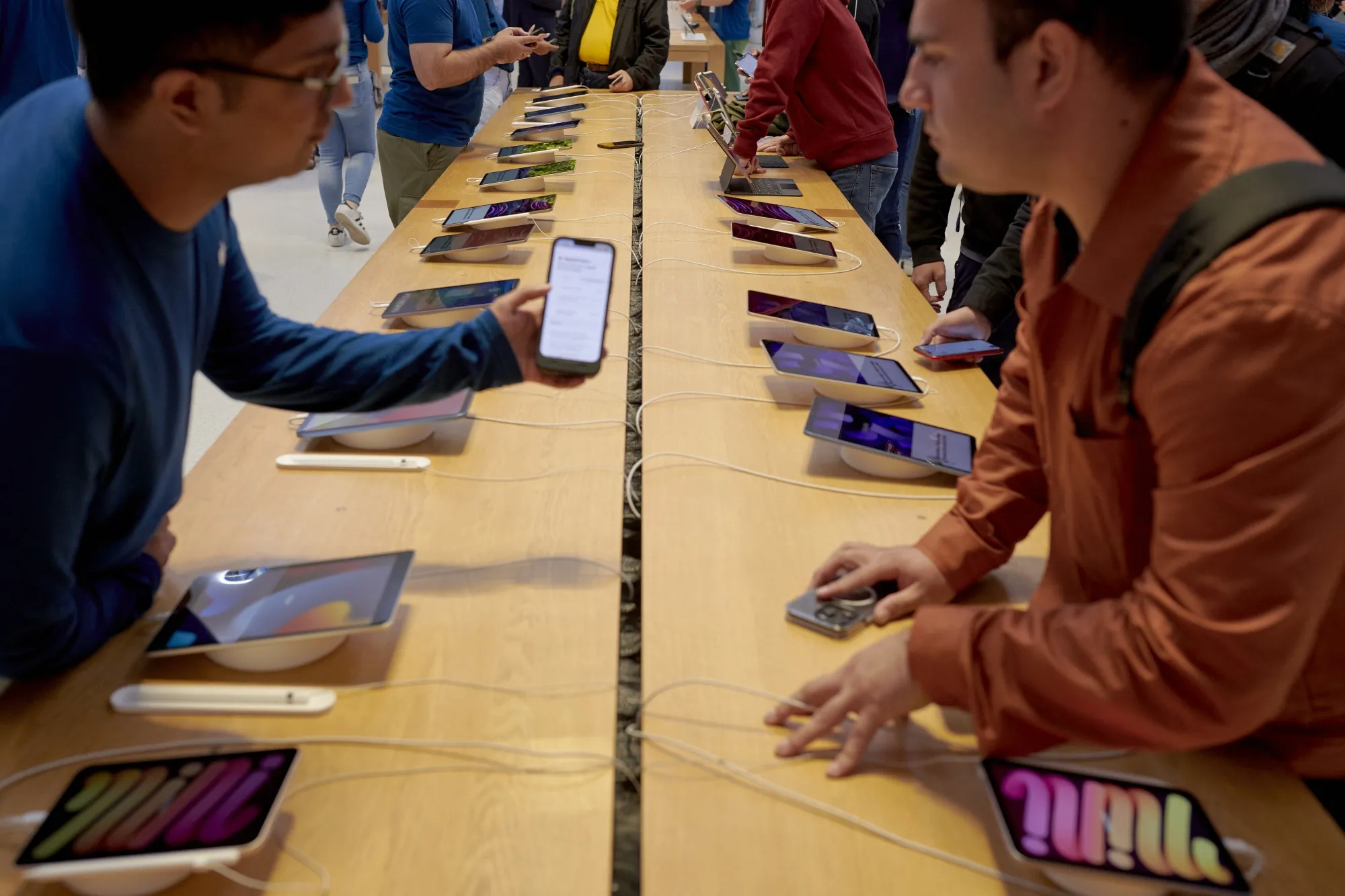 A worker assists a customer at the Apple Fifth Avenue store in New York.