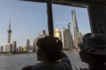 Passengers look out at the skyscrapers of the Pudong Lujiazui Financial District while taking a ferry across the Huangpu River in Shanghai.