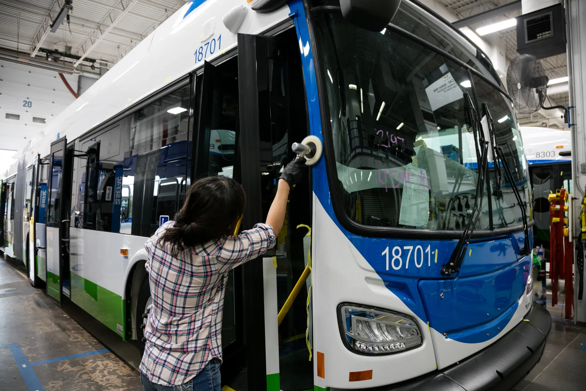 A worker polishes a new bus at the New Flyer Industries Ltd. manufacturing facility in St. Cloud, Minnesota, in&nbsp;2018.&nbsp;
