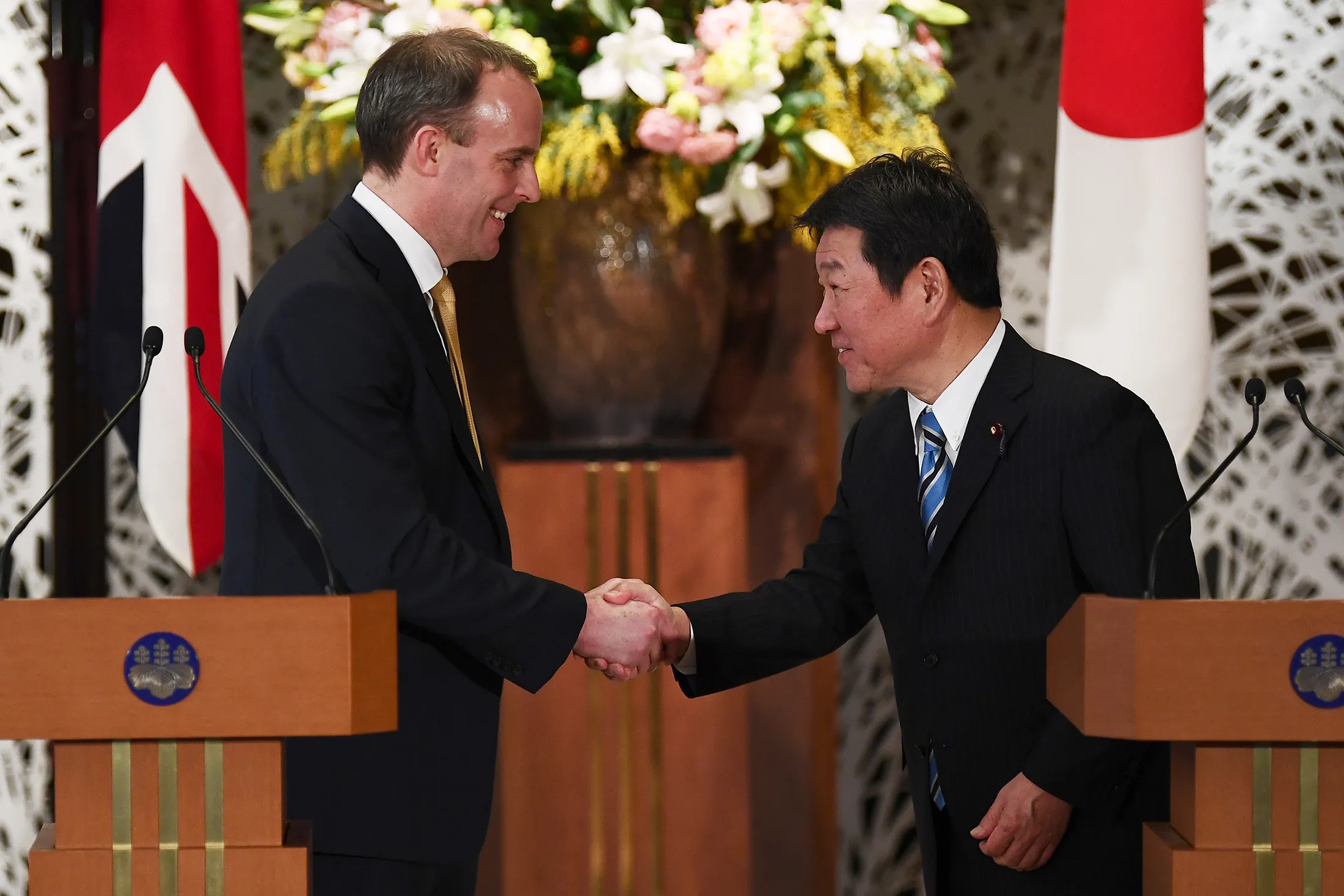 Dominic Raab, left, and Toshimitsu Motegi shake hands after a joint press conference in Tokyo on Feb. 8.