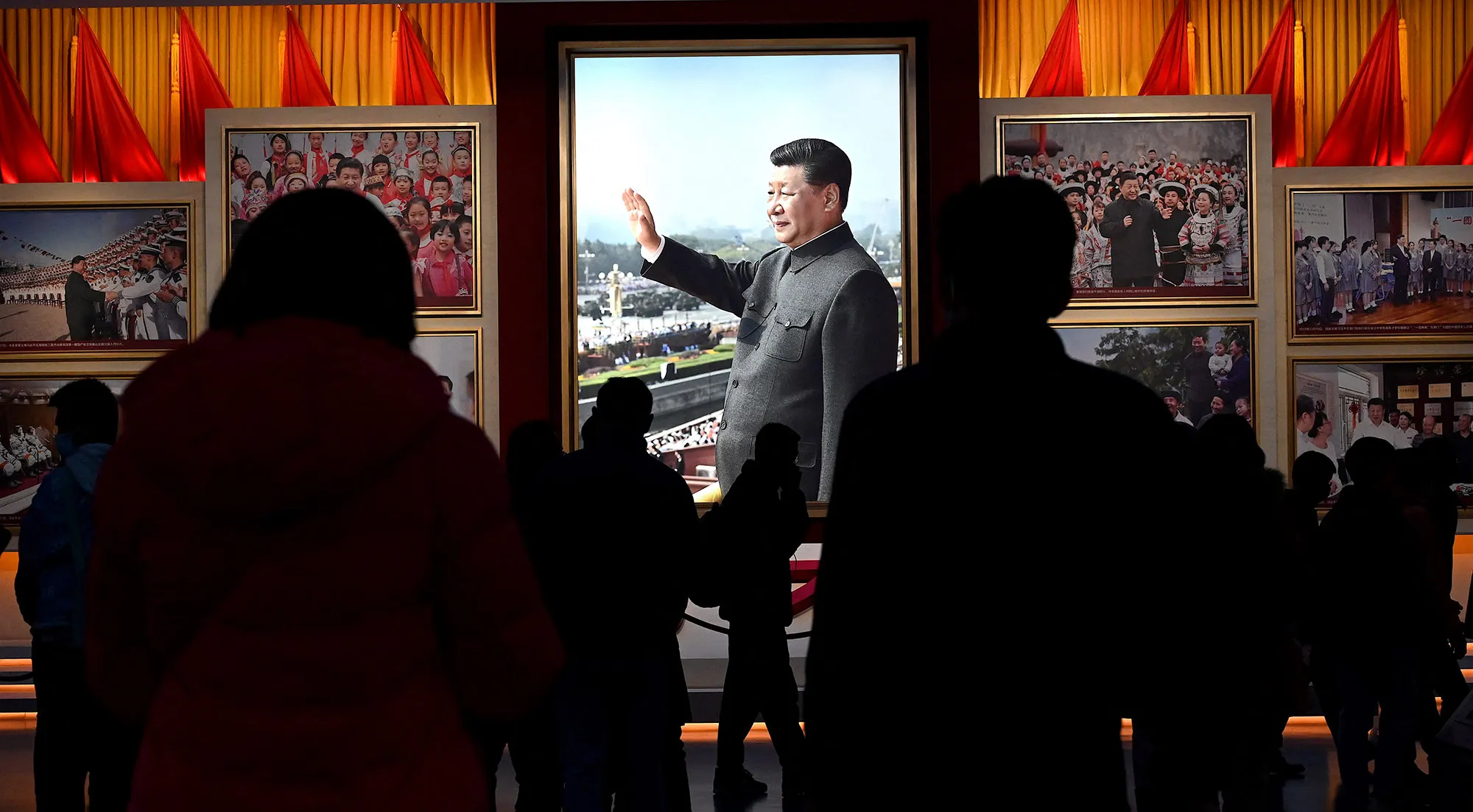 Visitors walk in front of a picture of China's President Xi Jinping at the Museum of the Communist Party of China in Beijing on Nov. 11, 2021.