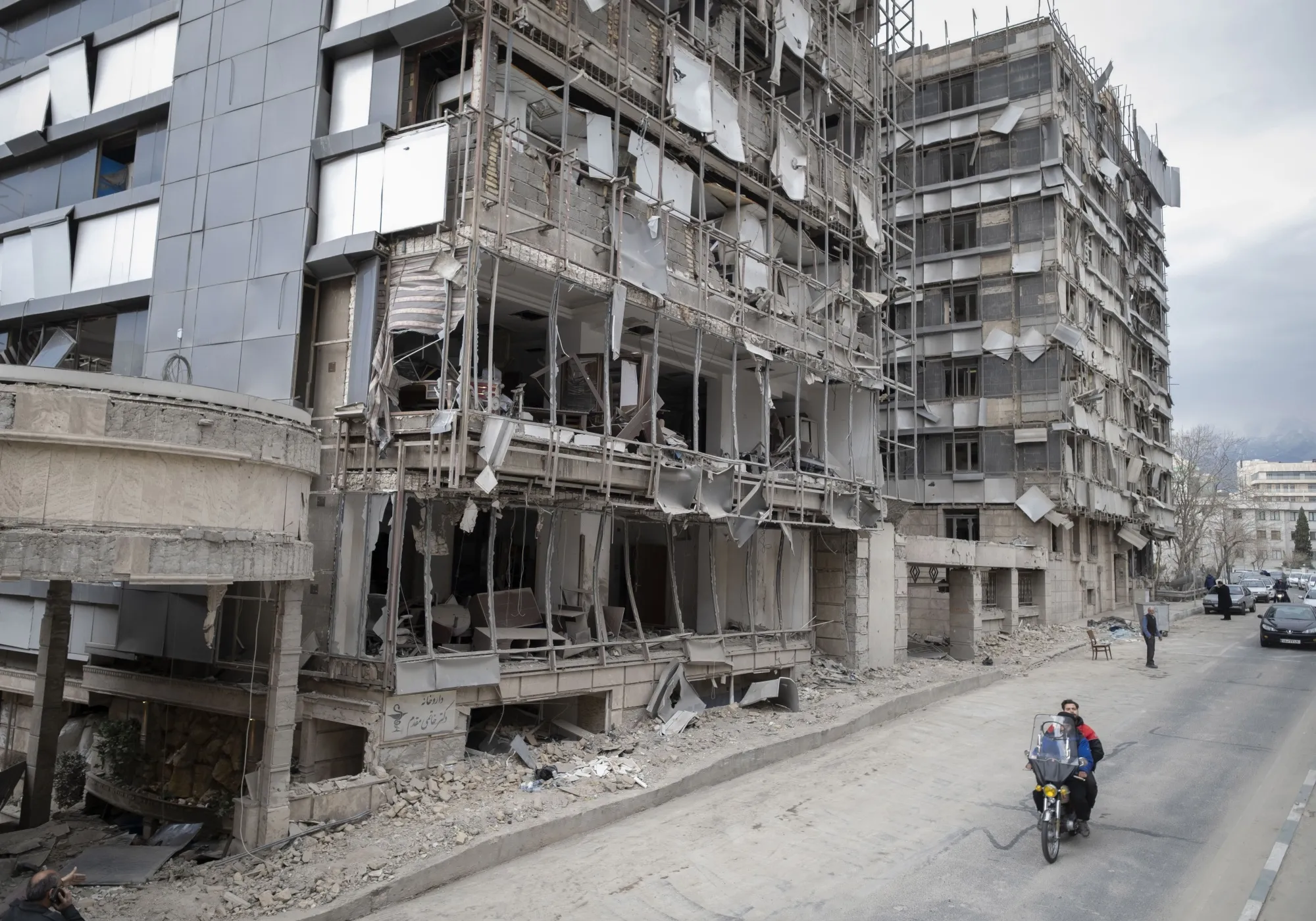 An Iranian motorcyclist rides past the Gandhi Hospital, which is damaged after U.S.-Israeli strikes in Tehran on March 2.