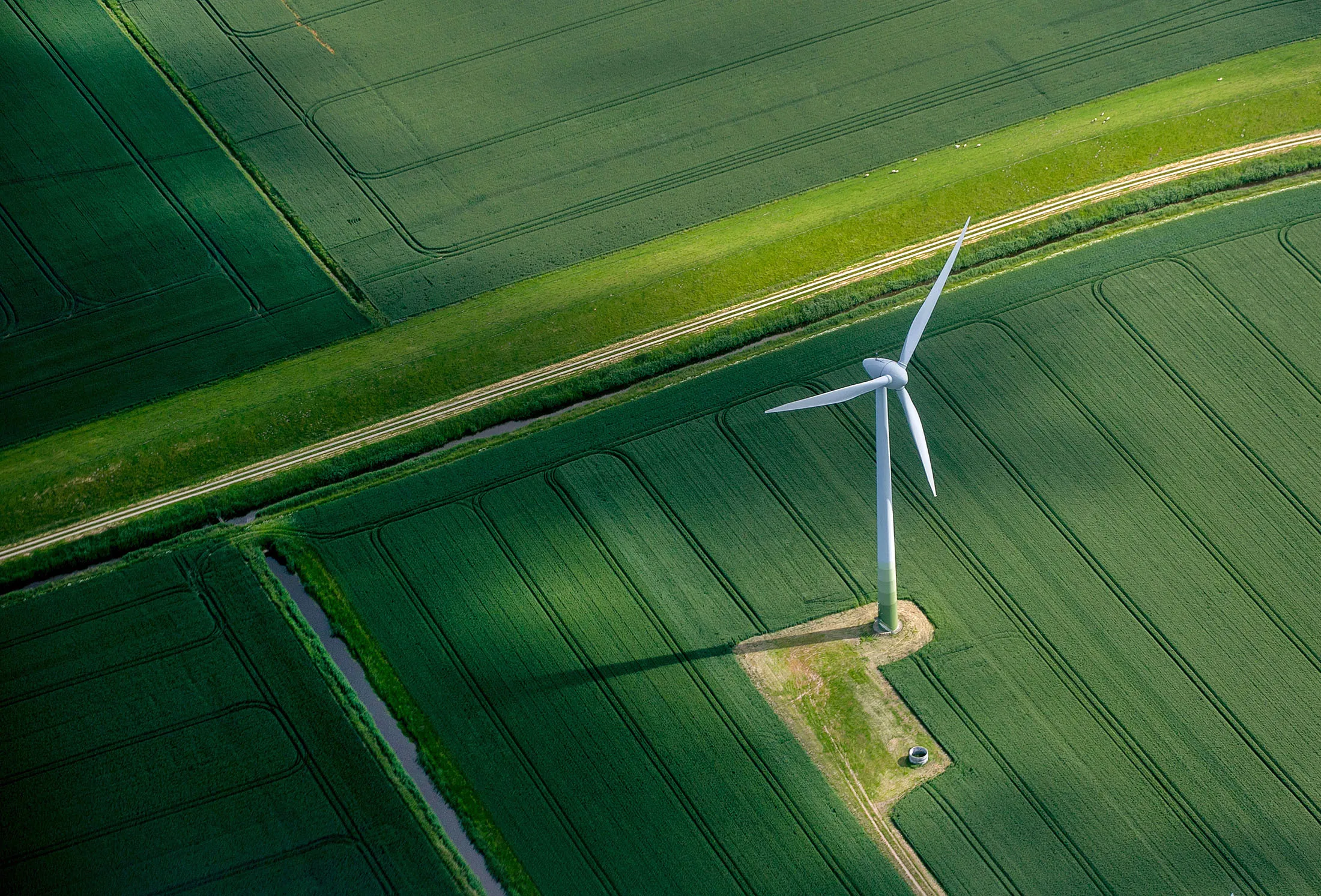 A wind turbine stands in a field of agricultural crops in this aerial photograph of farm land near Hamburg, Germany.
