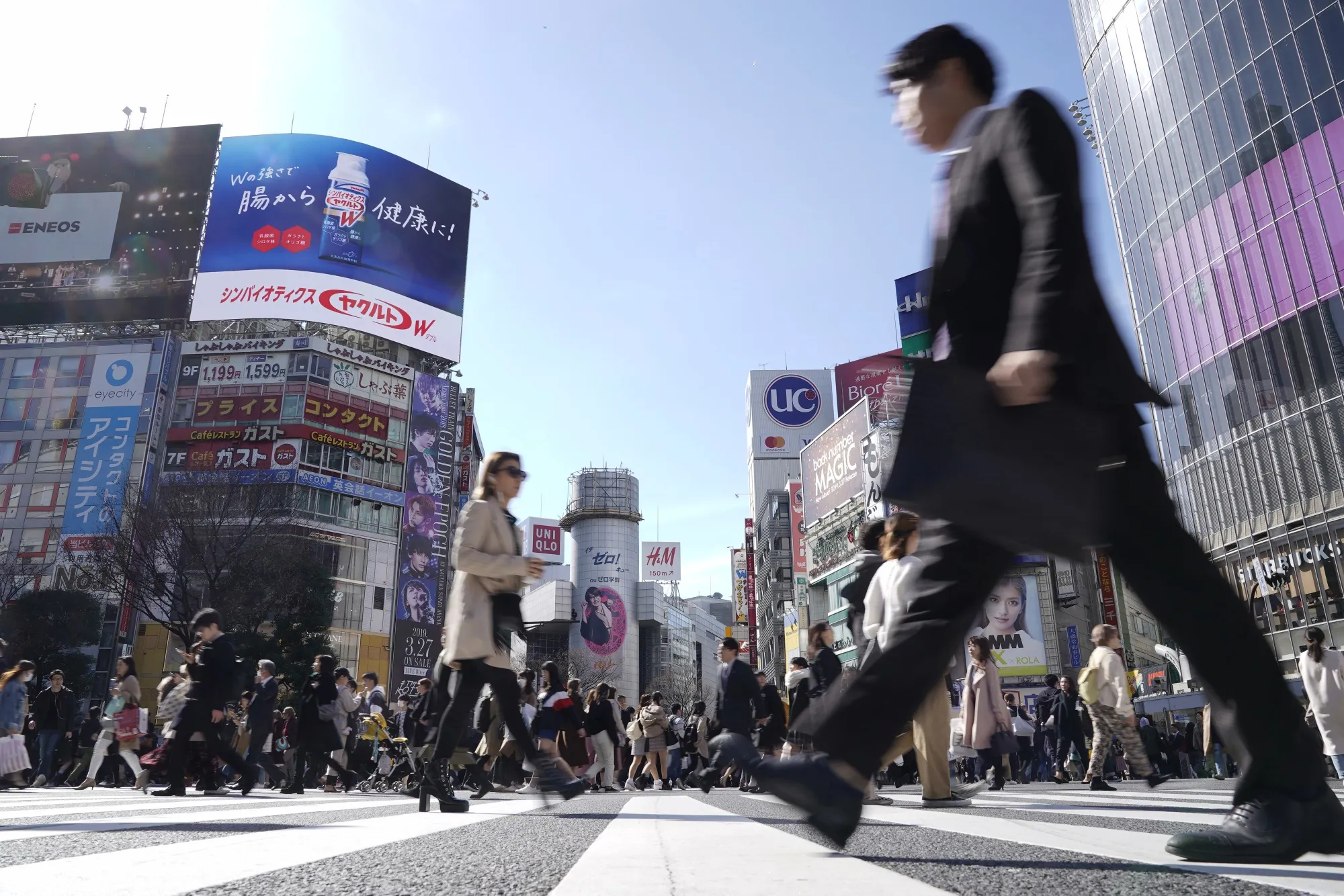 Pedestrians cross an intersection in the Shibuya district of Tokyo.