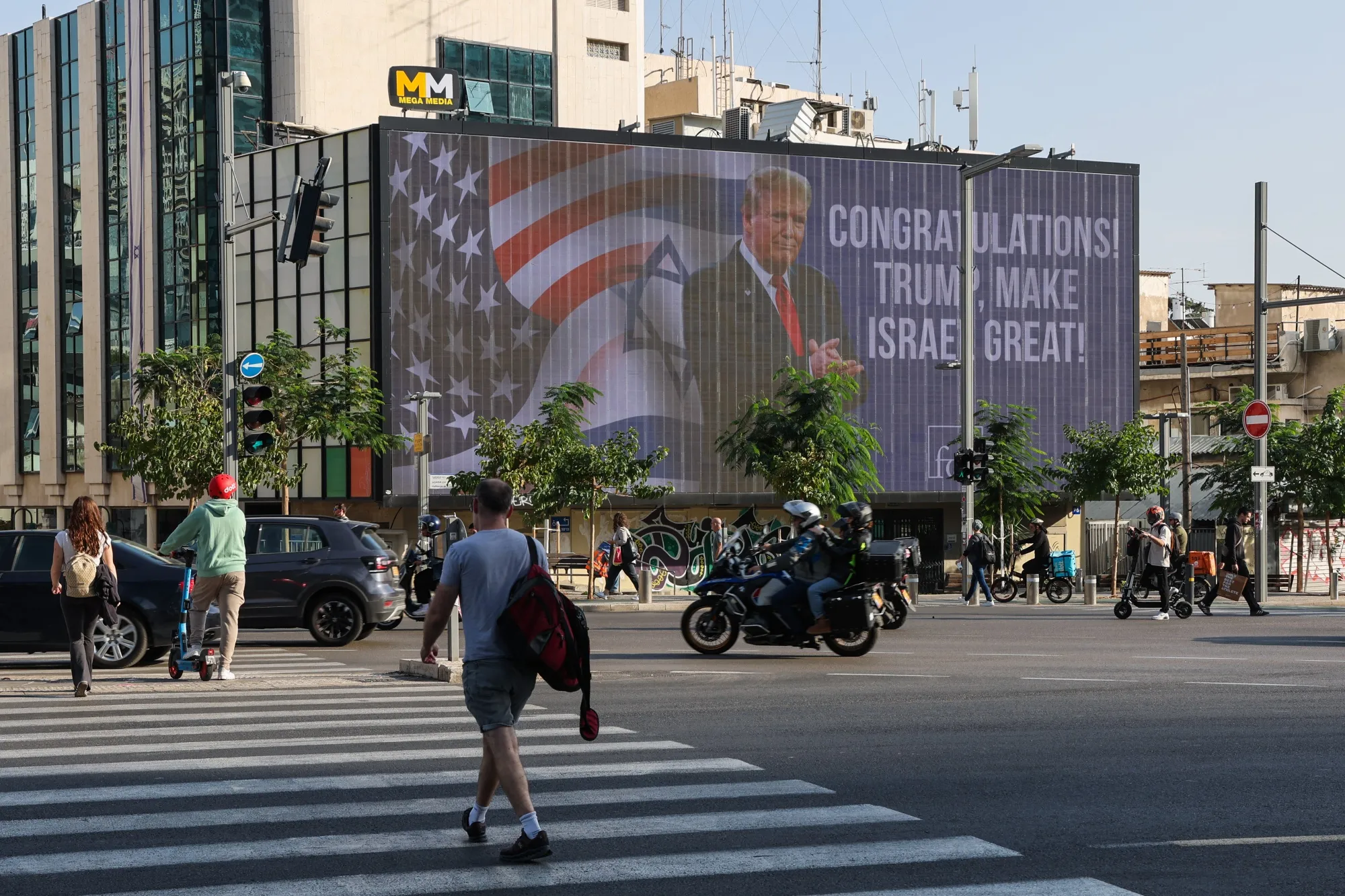 Cars drive past a large billboard congratulating&nbsp;Donald Trump in Tel Aviv on November 6, 2024.