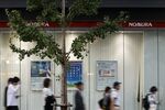 Signage and advertisements for Nomura Securities Co., a unit of Nomura Holdings Inc., displayed outside one of the company's branches in Tokyo. Photographer: Kiyoshi Ota/Bloomberg