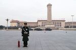 A member of the Chinese People's Armed Police stands guard next to a fire extinguisher in Tiananmen Square.