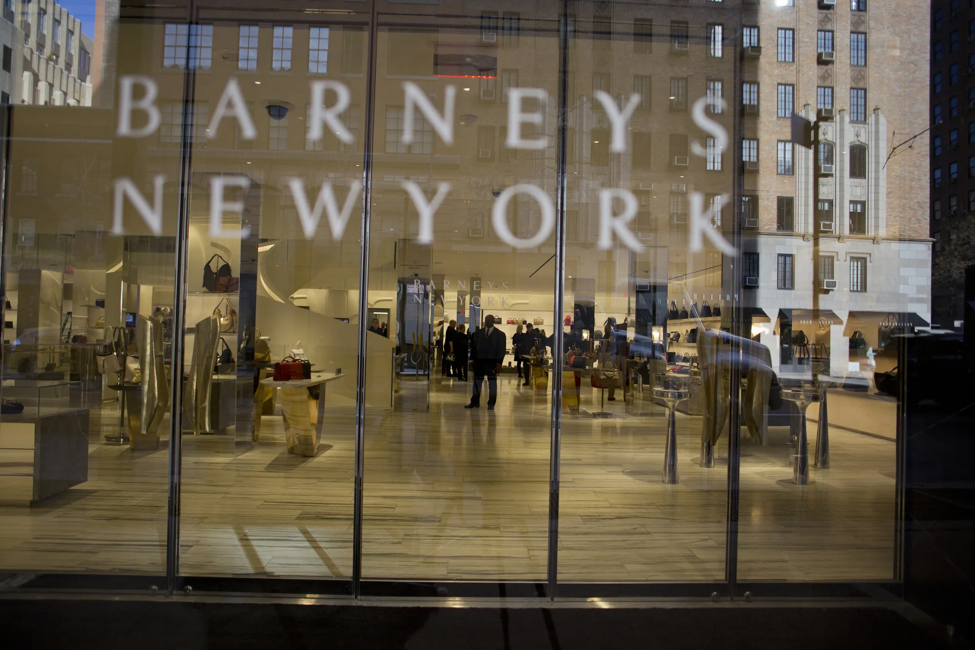 Employees work inside the Barneys New York retail store.