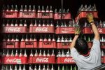A worker loads a delivery truck with empty Coca-Cola bottles in Mexico City, Mexico.