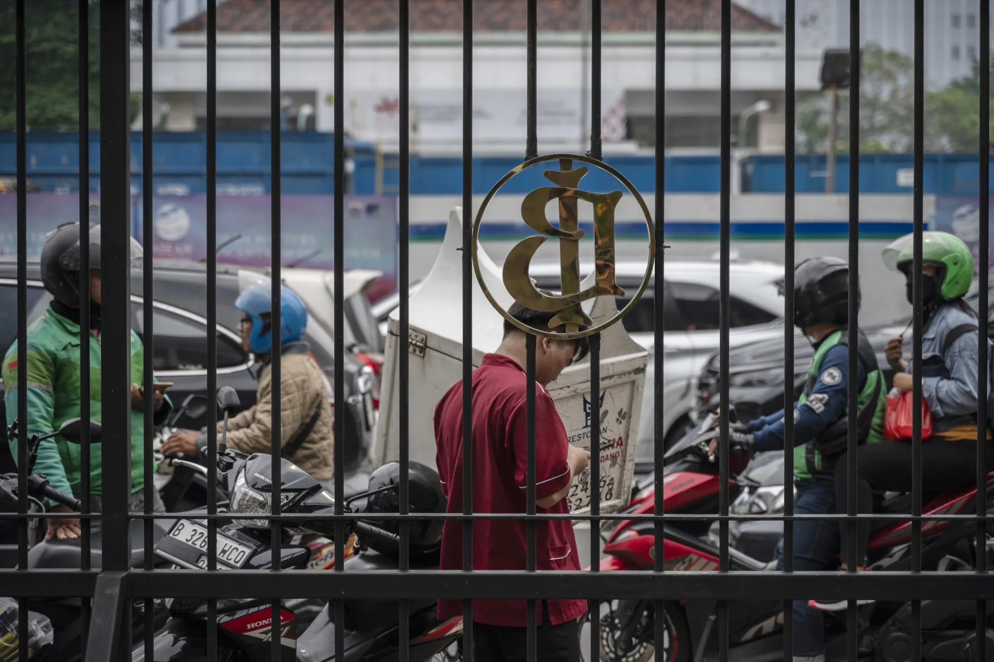 Pedestrians in front of the Bank Indonesia headquarters in Jakarta, Indonesia.