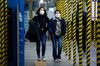 People wearing protective masks walk past scaffolding inside a subway station in Seoul, South Korea, on Monday, Feb. 24, 2020. 