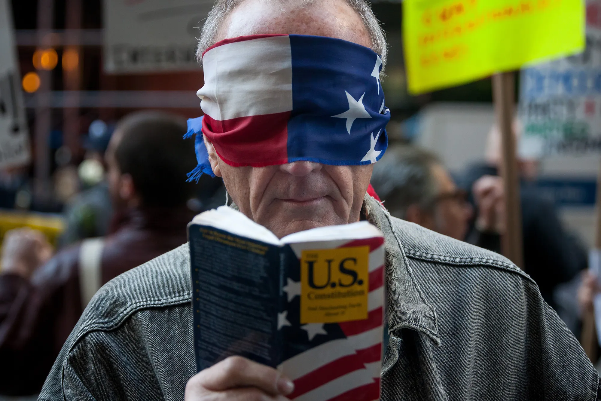 A blindfolded demonstrators holds a copy of the U.S. Constitution during a protest outside Hyatt Hotels Corp.'s Grand Hyatt at Grand Central Station, during the New York State Republican Gala in New York, on April 14, 2016.
