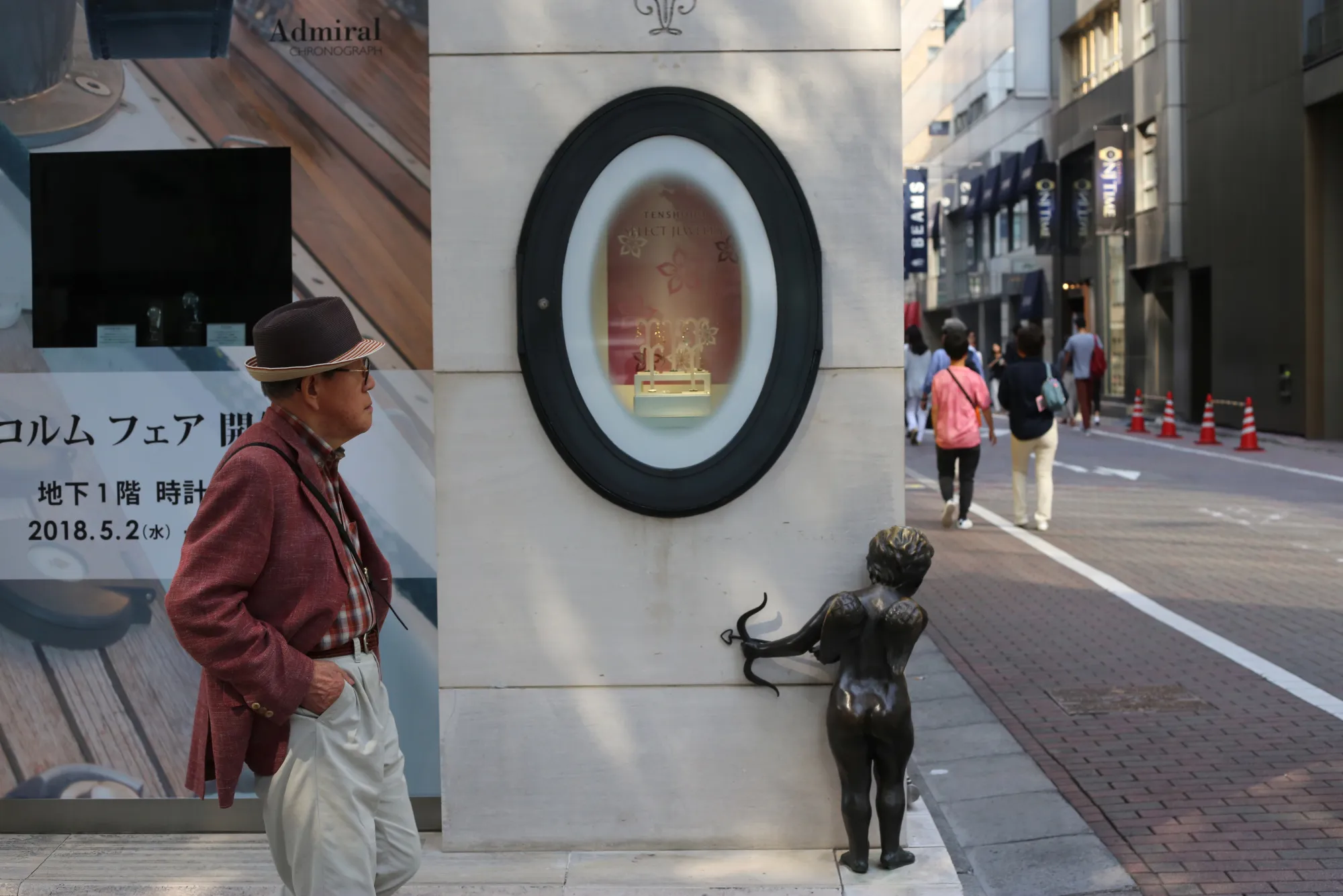 A pedestrian walks past an angel statue at the corner of a building in the Ginza district of Tokyo, Japan, in 2018.