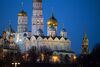 The golden domes of the Kremlin's churches and cathedrals sit illuminated at dusk in Moscow.