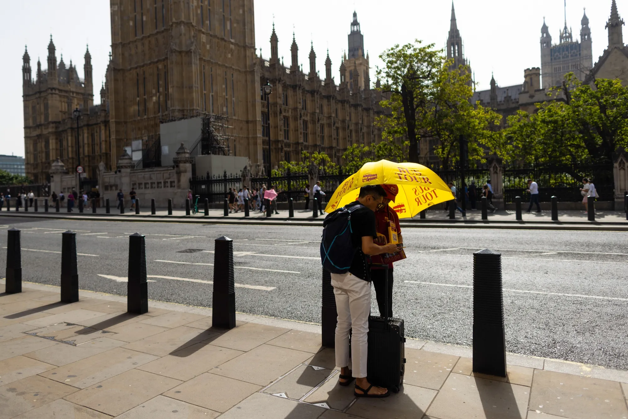 A tourist speaks with a tour guide under the shade of an umbrella in London during an early September heat wave. The world just experienced the hottest September on record.