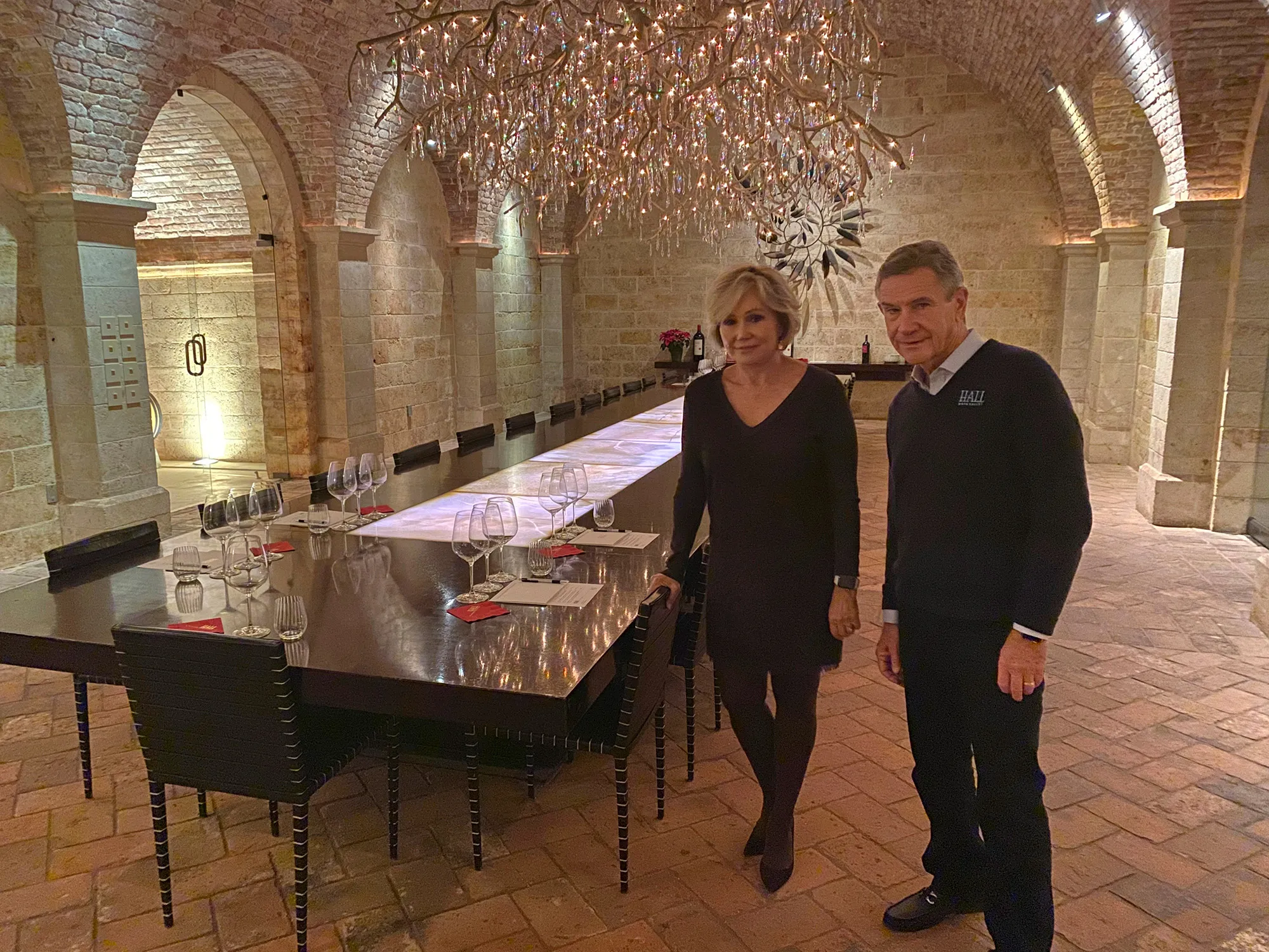 Kathryn and Craig Hall, owners of Hall Rutherford Winery, stand inside the “wine cave” dining room where the fundraiser was held.&nbsp;