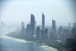 Residential and commercial skyscrapers stand along the coastline in Abu Dhabi, United Arab Emirates.